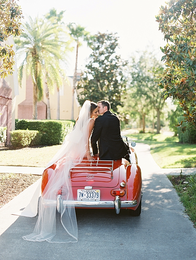 Red convertible get away car for bride and groom