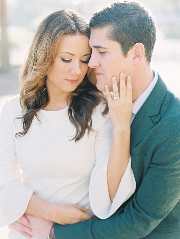 beautiful white gown and engagement ring, groom in green suit jacket