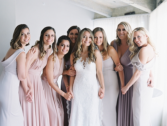 bridesmaids and bride all dressed and ready to go, posing for a portrait looking at camera smiling | NYC Wedding Photographer | Beacon Roundhouse New York Wedding | photographed by Kt Crabb Photography