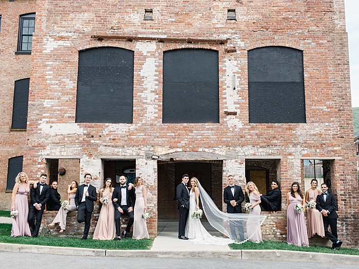 entire wedding party standing in front of a brick building posed stylistically | NYC Wedding Photographer | Beacon Roundhouse New York Wedding | photographed by Kt Crabb Photography