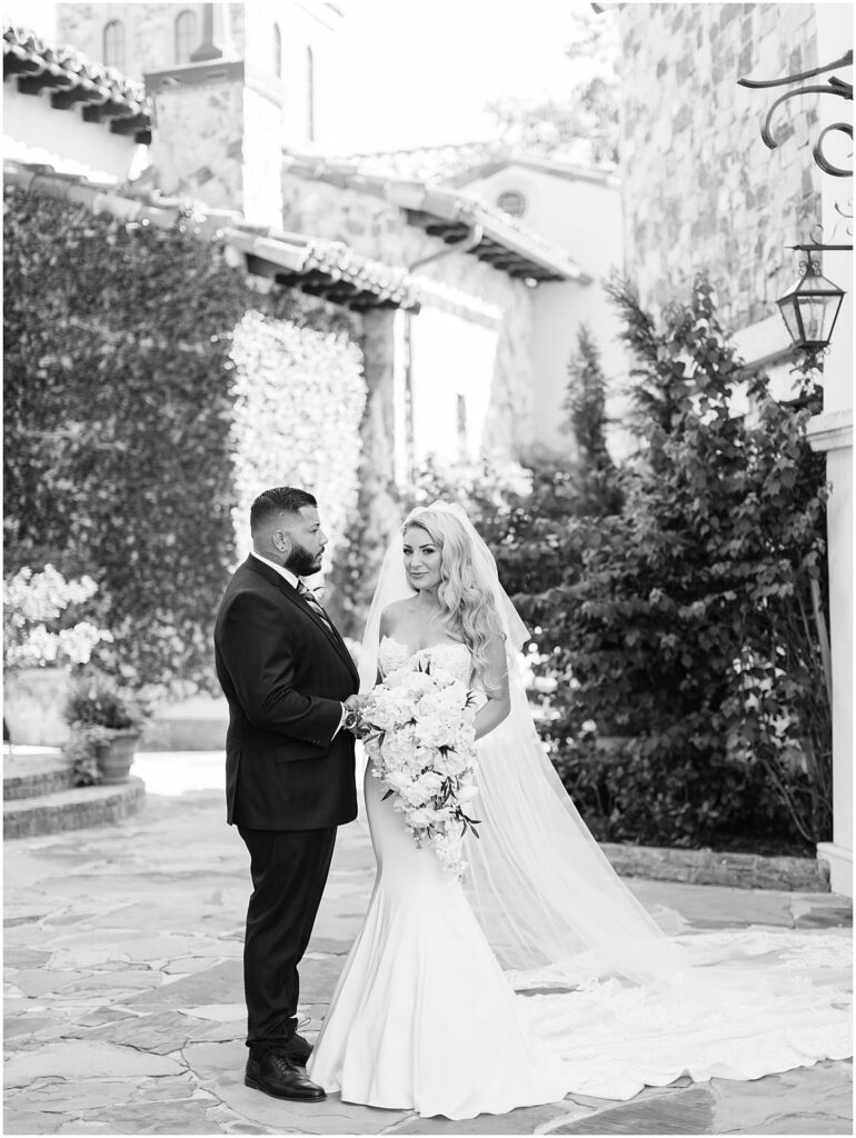 bride holding bouquet while standing next to groom in black and white photo at Bella Collina Orlando Wedding