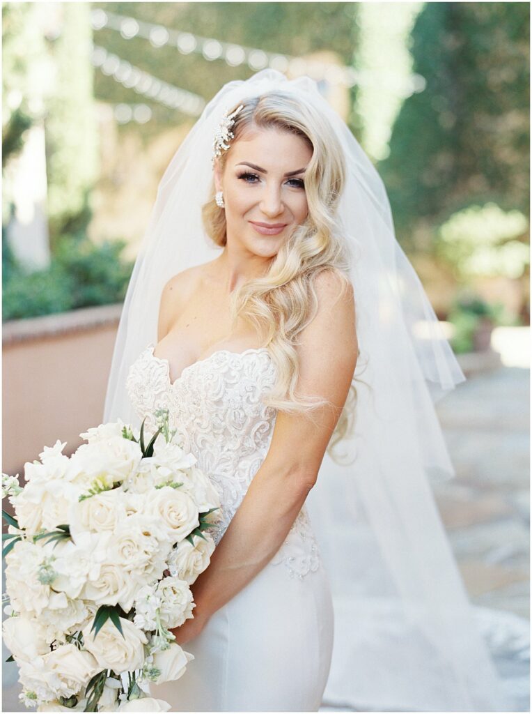 bride in strapless lace dress and cathedral veil holding white bouquet at Bella Collina Orlando Wedding