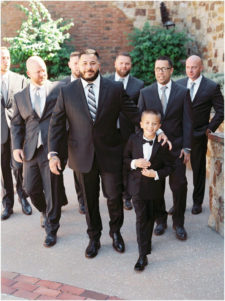 groom walking with son and groomsmen at Bella Collina Orlando Wedding