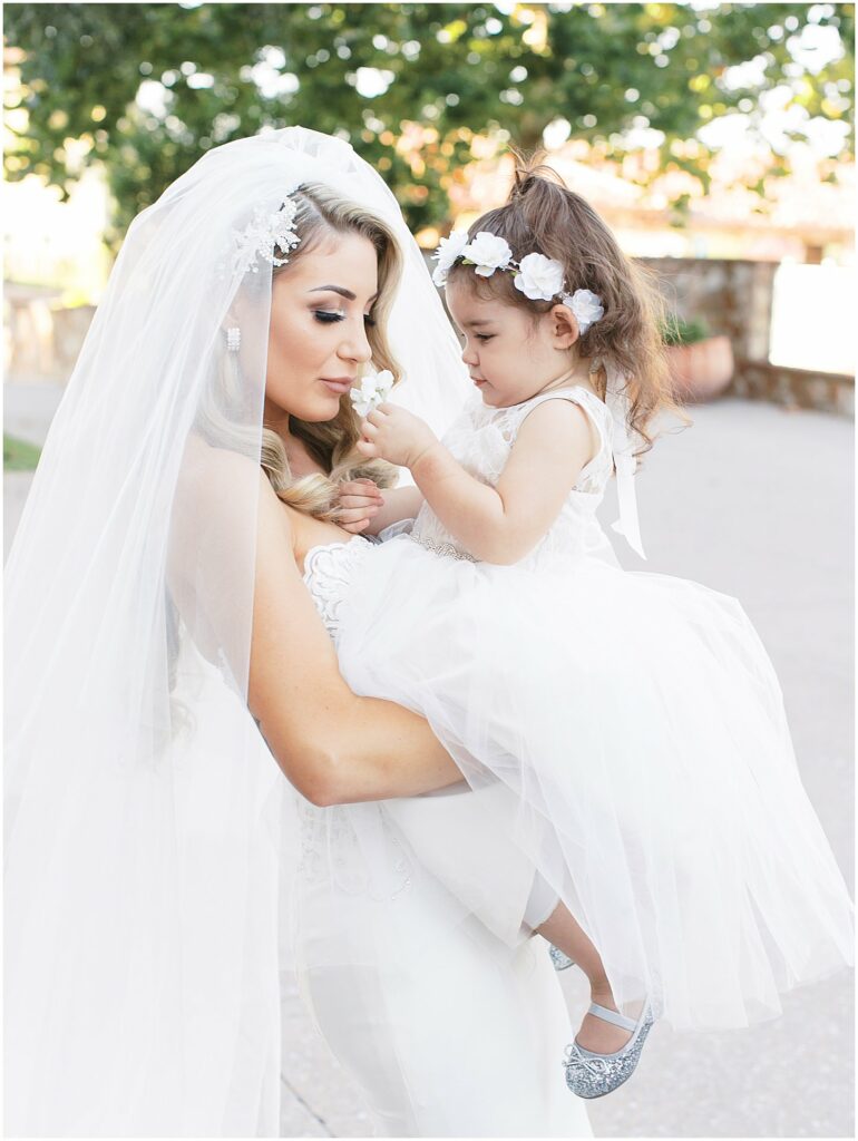 bride holds flower girl at Bella Collina Orlando Wedding