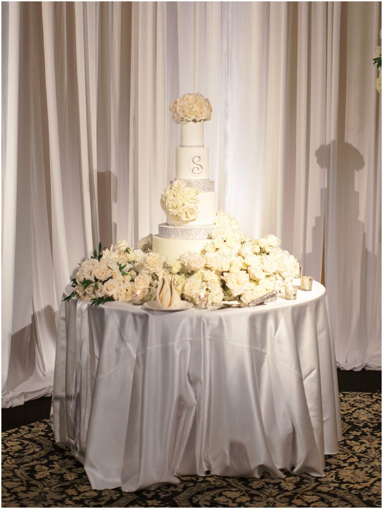 white four teared wedding cake with rinestones and white roses at Bella Collina Orlando Wedding