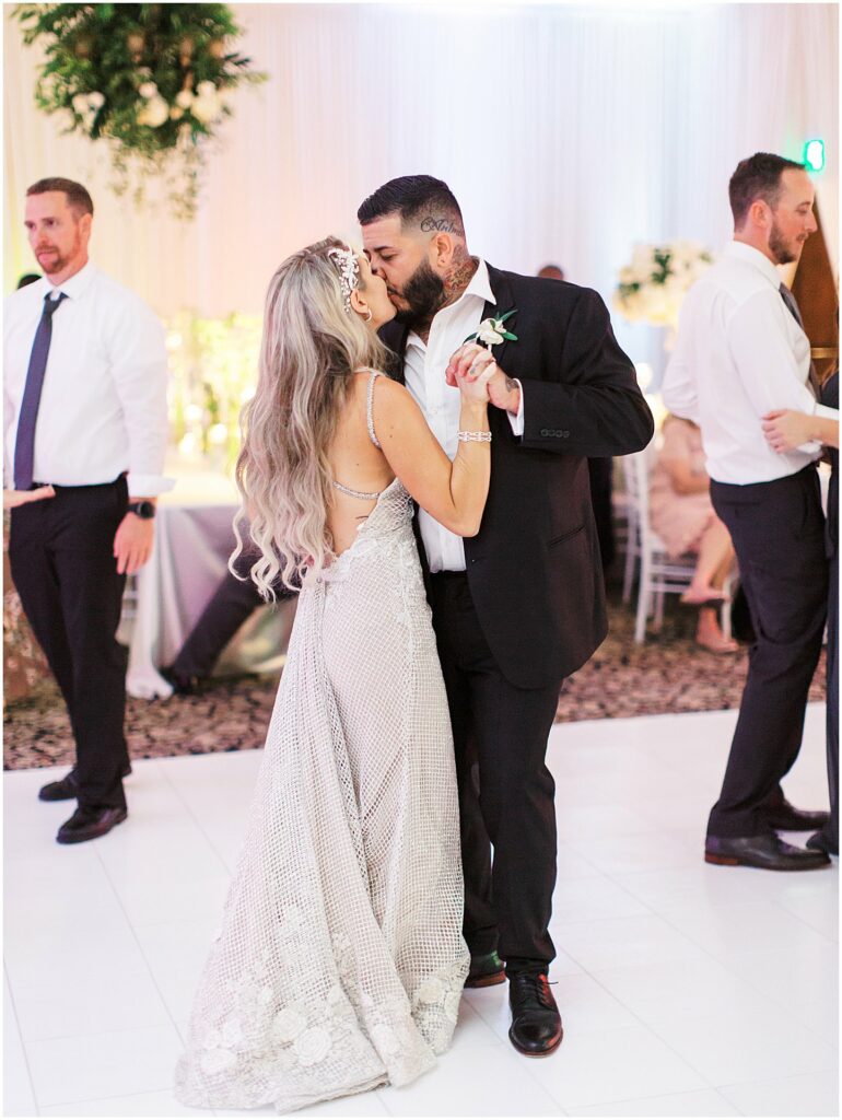 bride and groom kiss on all white dance floor during last dance at Bella Collina Orlando Wedding