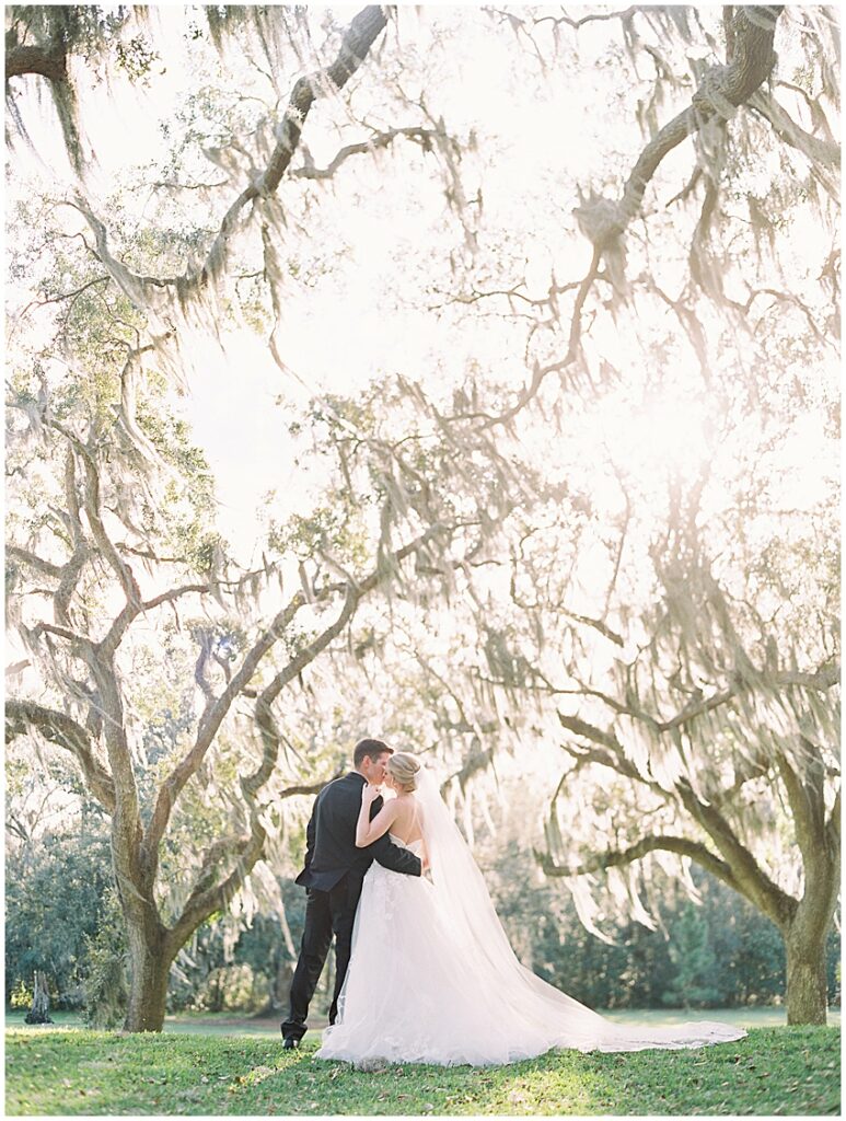 Bride and groom kiss in the oak trees at bok tower gardens wedding