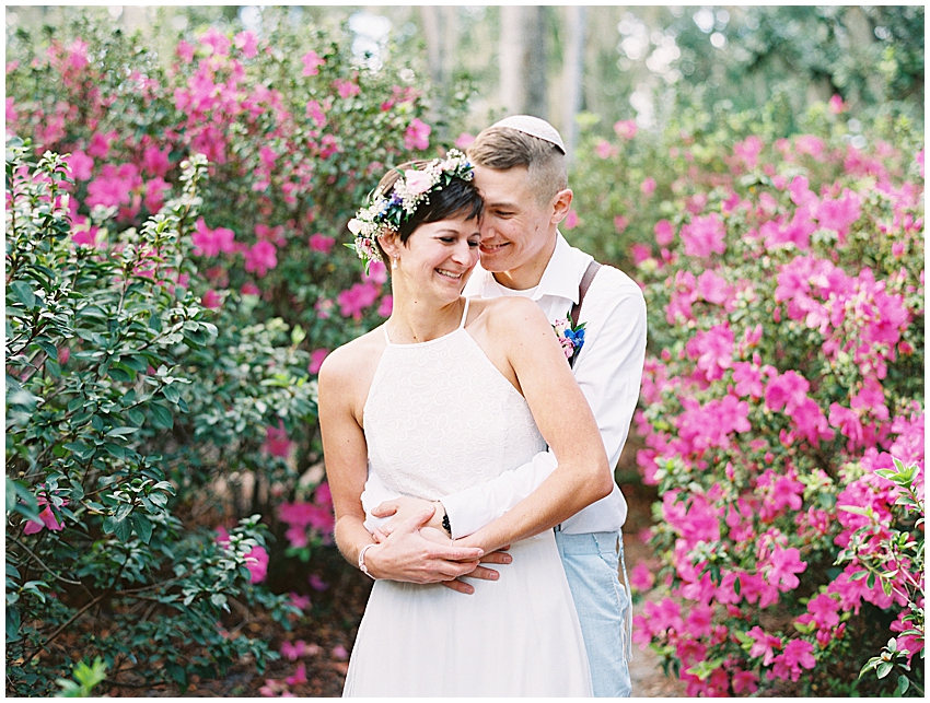 jewish bride an groom hug with azalea bushes around them at Dickson azalea park orlando wedding