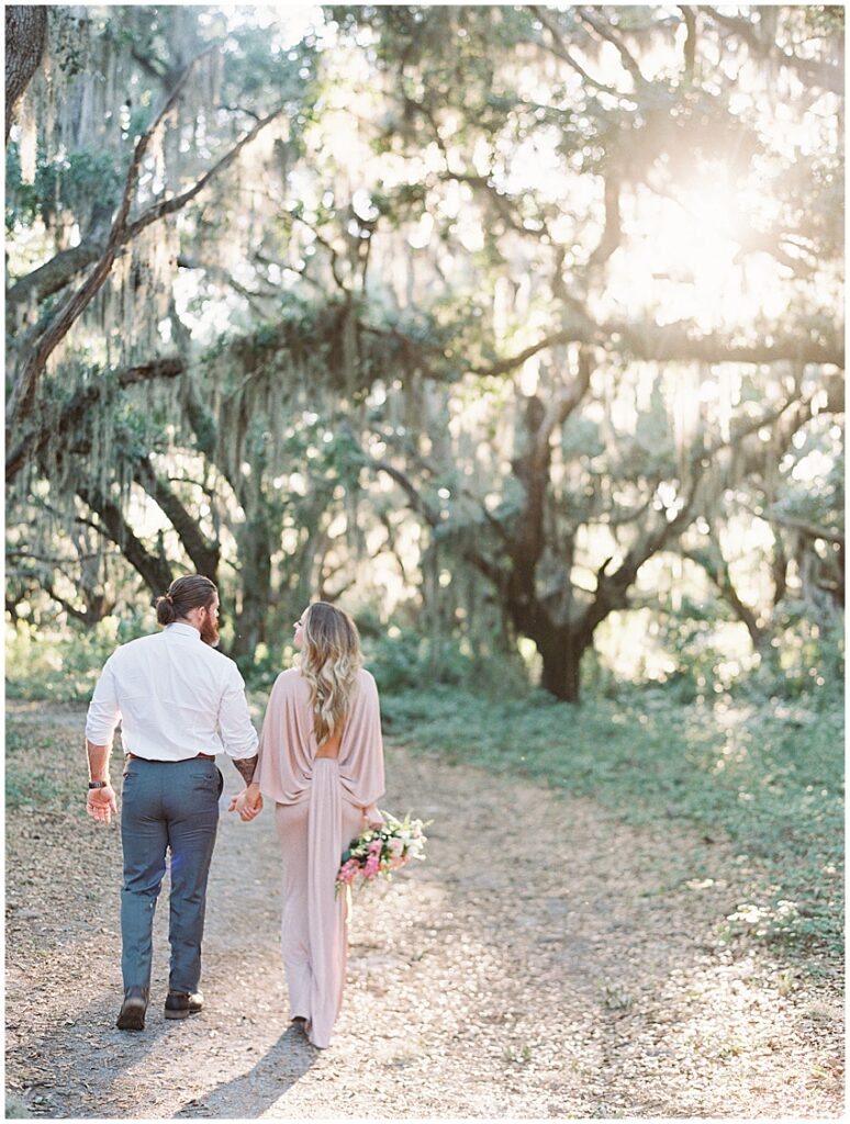 man and wife hold hands walking into sunset anniversary session orlando photographer