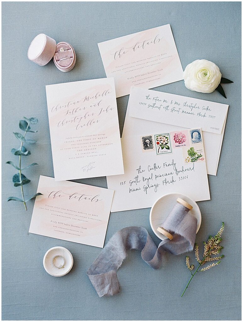 Minted invitation suite and wedding rings on display at the Addison in boca raton Miami wedding photographer