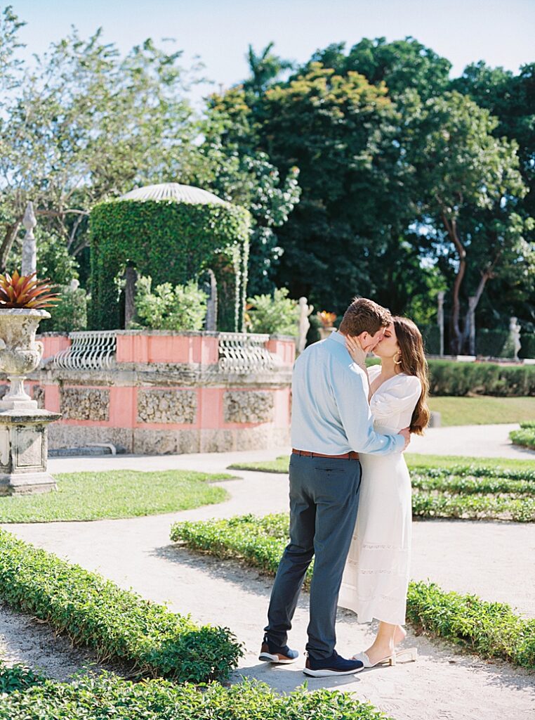 A couple kisses in the garden of Vizcaya Museum photographed by Kt Crabb Photography